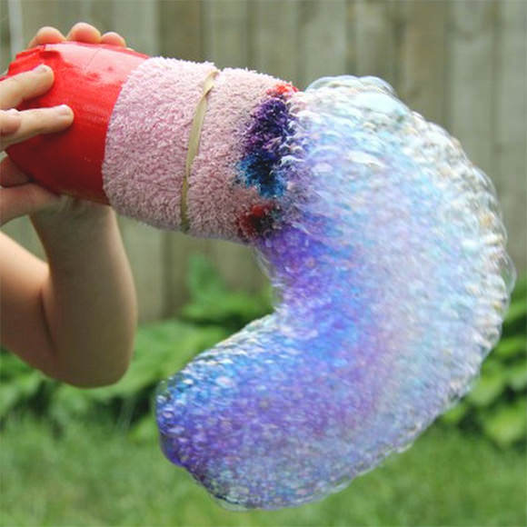 Creeză un curcubeau de baloane! Vei avea nevoie de: o sticlă de plastic, un ciorap flaușat, bandă adezivă, colorant alimentar și detergent de vase. Taie partea de jos a sticlei de plastic și lipește șoseta peste ea. Pune niște colorant alimentar pe șosetă și amestecă detergentul de vase cu apă. Înmoaie sticla în acest amestec și suflă.